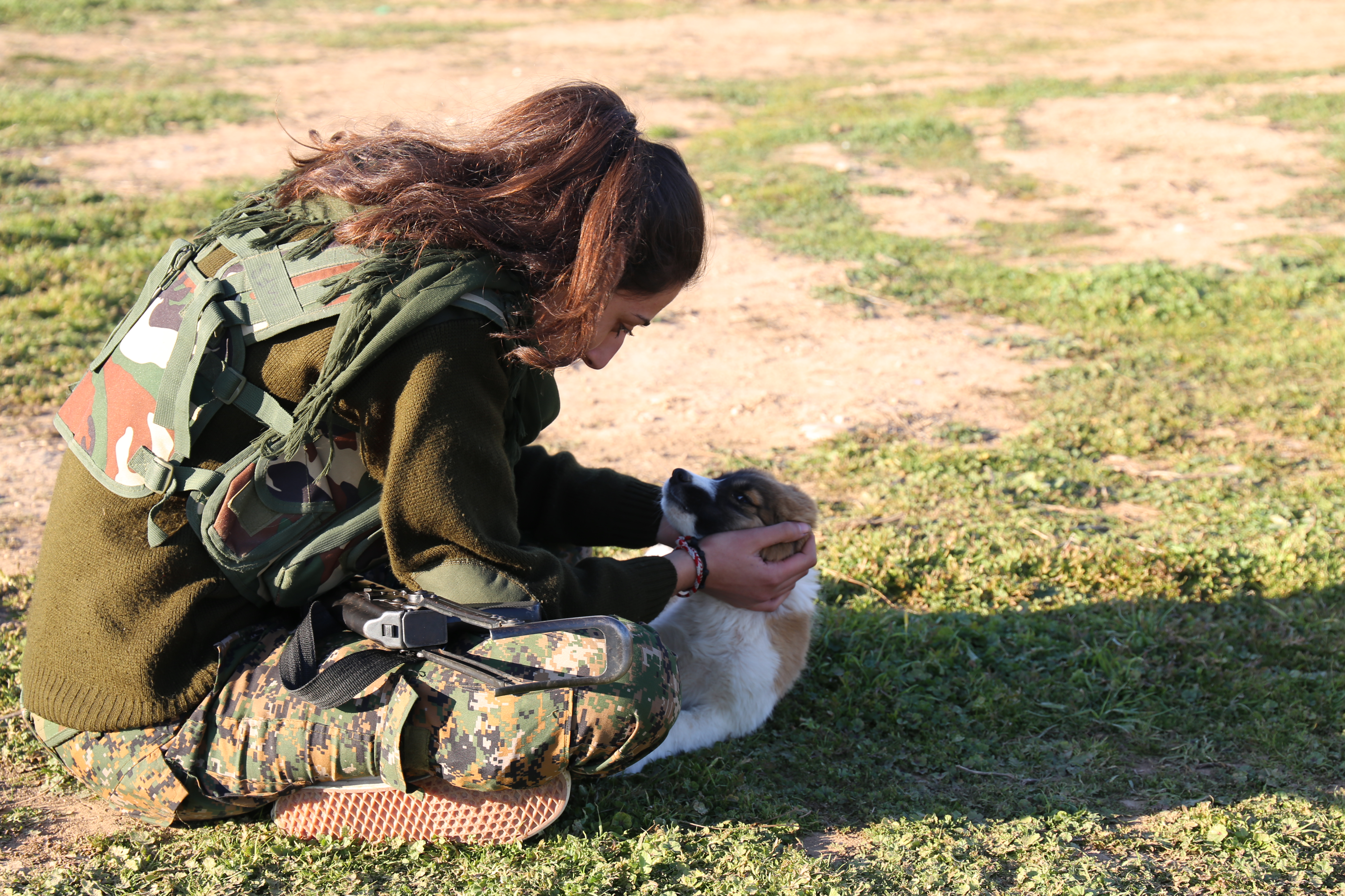 Soldier playing with puppy