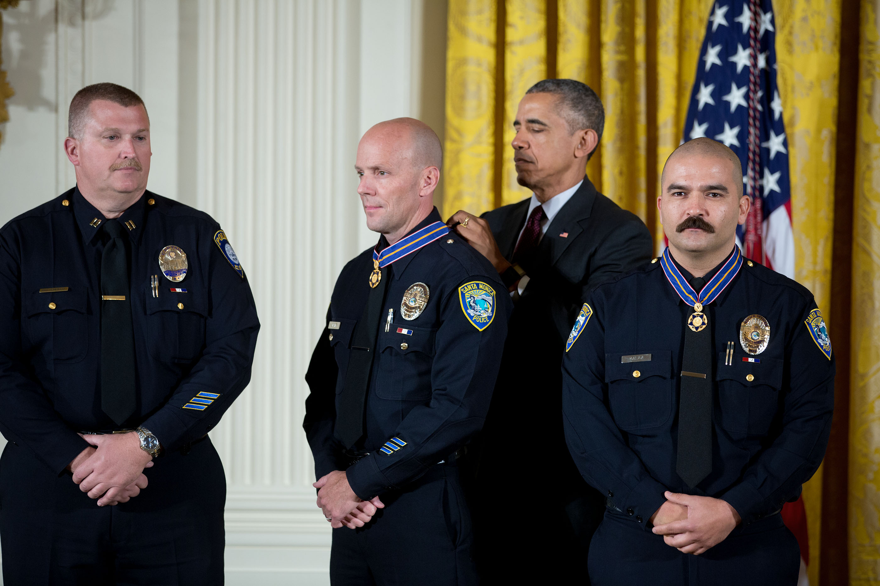 President Barack Obama awards the Medal of Valor to Officer Jason Salas, Officer Robert Sparks, and Captain Raymond Bottenfield of the Santa Monica College Police Department, Calif., during a ceremony in the East Room of the White House, May 16, 2016. The Medal of Valor is awarded to public safety officers who have exhibited exceptional courage, regardless of personal safety, in the attempt to save or protect others from harm. (Official White House Photo By Chuck Kennedy)