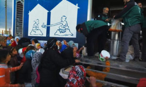 Refugees wait for food Credit: hinkelstone/Flickr