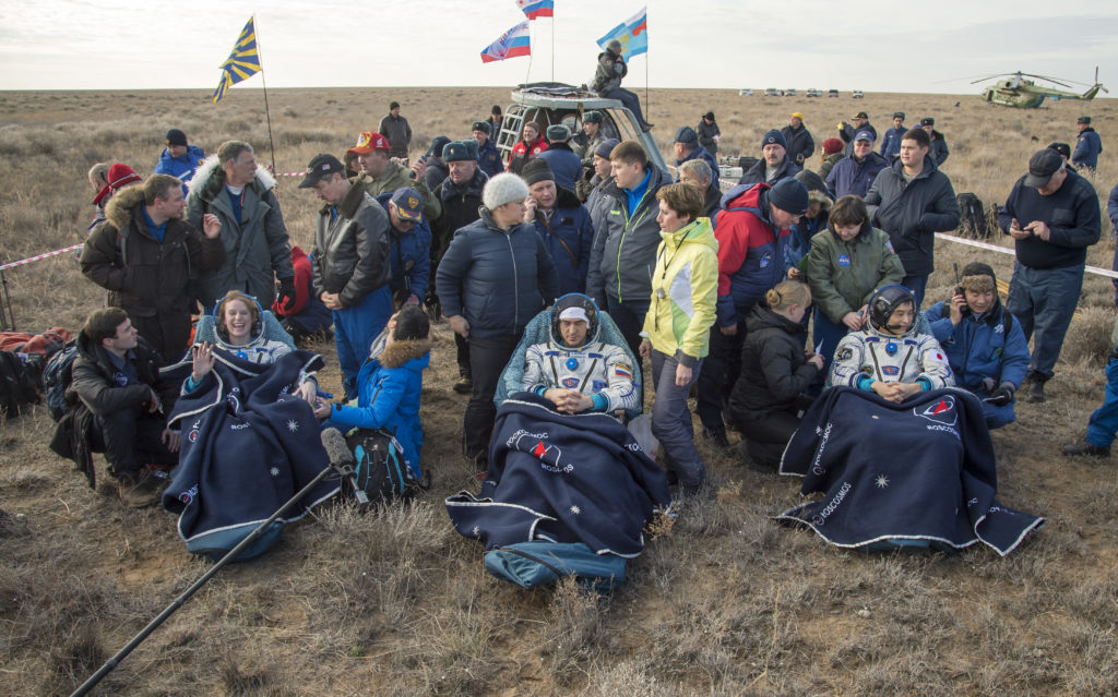 NASA astronaut Kate Rubins, left, Russian cosmonaut Anatoly Ivanishin of Roscosmos, center, and astronaut Takuya Onishi of the Japan Aerospace Exploration Agency (JAXA) sit in chairs outside the Soyuz MS-01 spacecraft a few moments after they landed in a remote area near the town of Zhezkazgan, Kazakhstan on Sunday, Oct. 30, 2016 (Kazakh time).Rubins, Ivanishin, and Onishi are returning after 115 days in space where they served as members of the Expedition 48 and 49 crews onboard the International Space Station. Photo Credit: (NASA/Bill Ingalls)