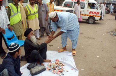 Abdul Sattar Edhi, with his fleet of ambulances in the background